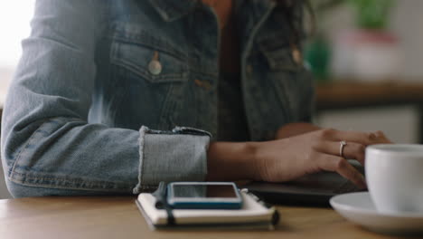 giovane donna afroamericana che usa un computer portatile in un caffè studente che condivide idee di stile di vita di successo sui social media che scrive e-mail che lavora godendo della tecnologia a mani chiuse