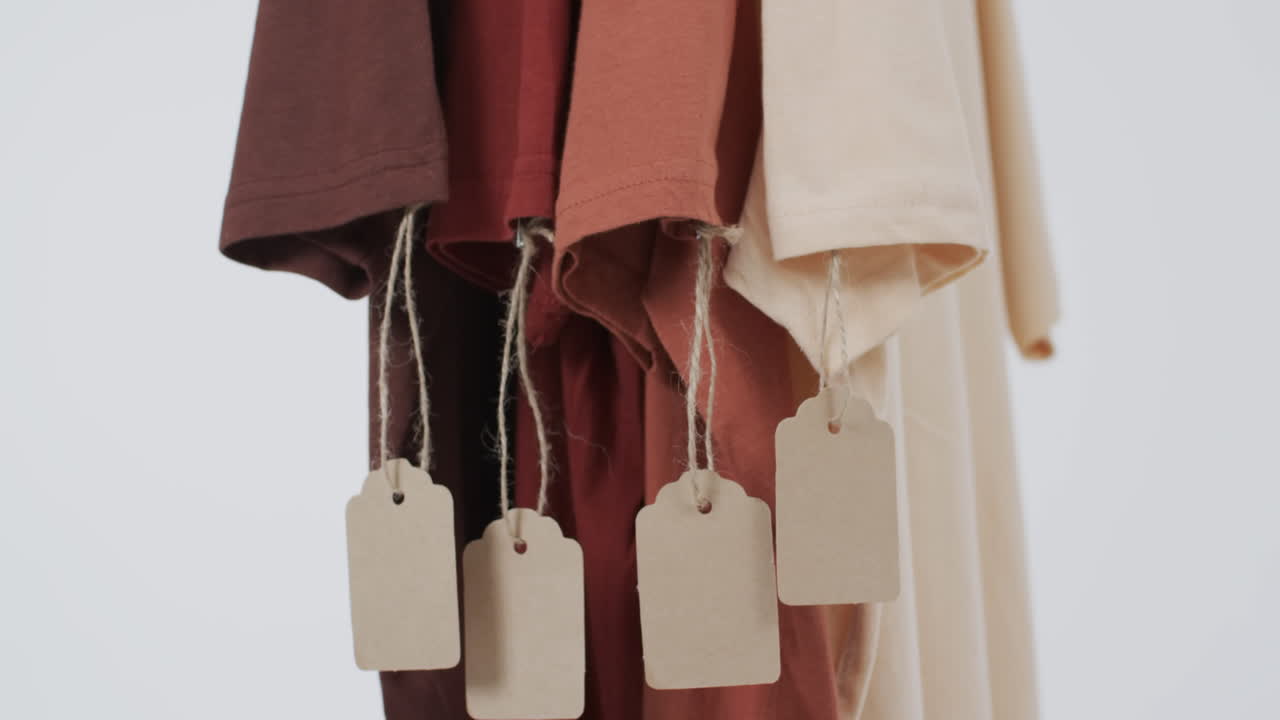 ⁇ 색 배경에 태그와 복사 공간을 가진 네 개의 t 셔츠의 비디오