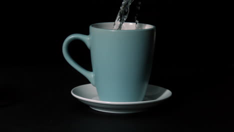 agua caliente que se vierte en la taza azul