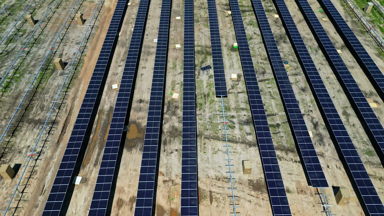 Row of solar panels on construction site for new power plant, aerial establisher