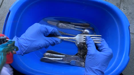 washing silverware in a basin