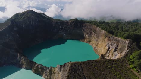 aerial descending shot of the crater from the kelimutu volcano at flores island, indonesia