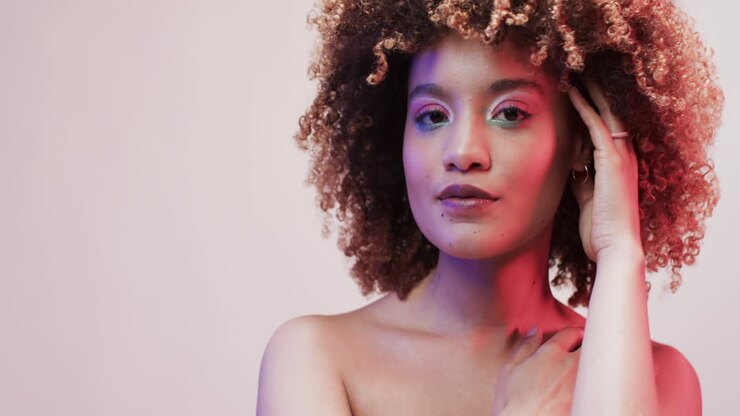 Biracial woman with dark hair in blue and pink light with copy space, slow motion