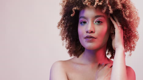 mujer biracial con cabello oscuro en luz azul y rosa con espacio de copia, cámara lenta