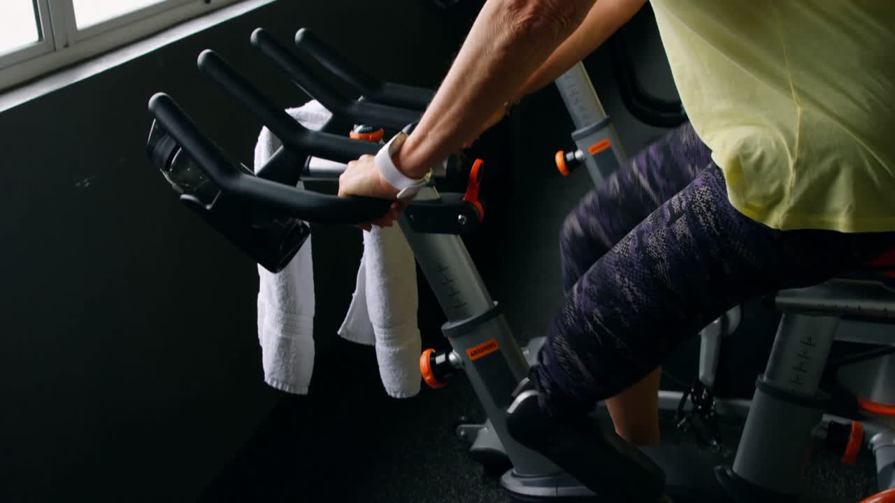 운동 자전거 4k에서 운동을 하는 고령 여성