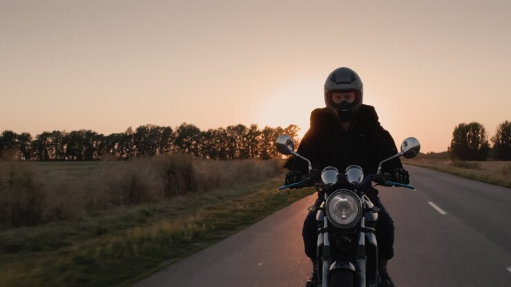 biker fährt in den strahlen der untergehenden sonne auf der autobahn 1