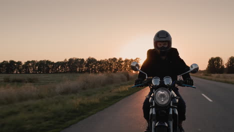 motorrijder rijden in de stralen van de ondergaande zon op de snelweg 1