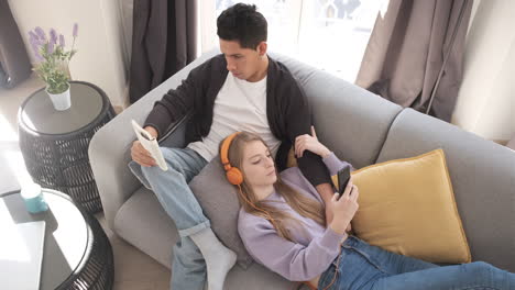 Top view of a young couple relaxing and spending time together on the couch while staying at home.