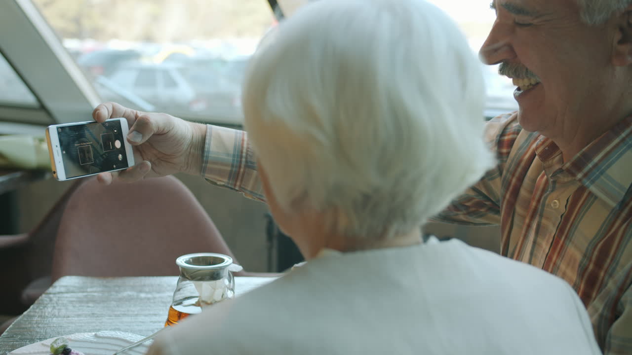 Senior Couple Taking a Selfie in a Cafe