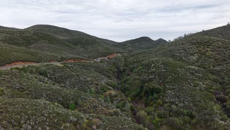 flying high above ca-49, this drone view captures the scenic curves of the golden chain highway as a car winds through the rustic hills.