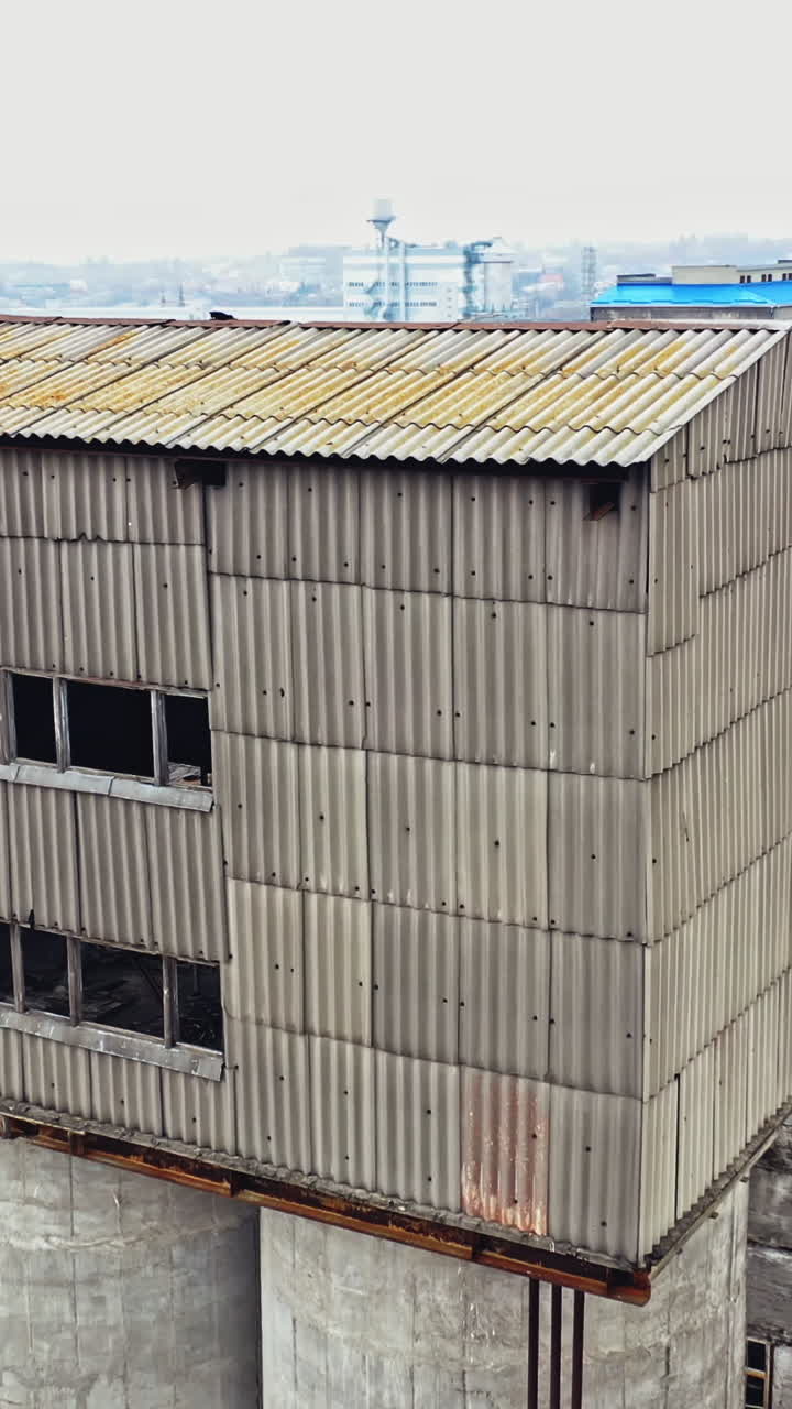 Flight over the empty old plant almost ruined in the city after the war. Old abandoned buildings without windows are broken-down. Camera moves around Vertical video