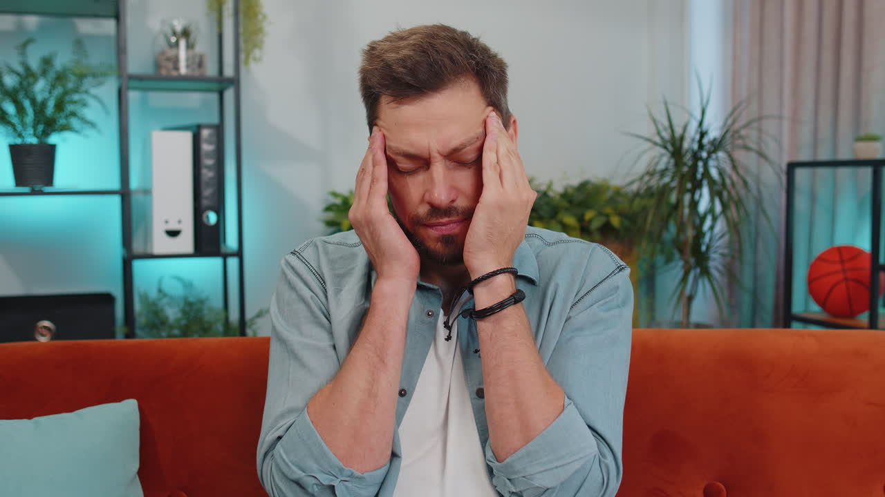 joven descontento frotando las sienes para curar el problema del dolor de cabeza, sufriendo de migraña, estrés