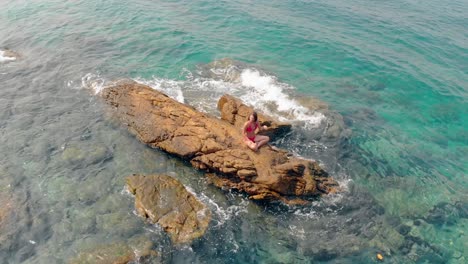 la cámara se acerca a una hermosa niña tierna sentada en una piedra marrón