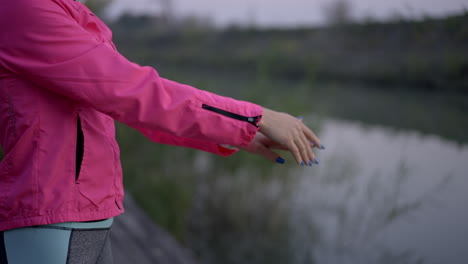 woman stretching arms by a river during outdoor workout