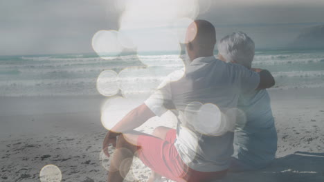 animation of happy senior african american couple embracing at beach over sea