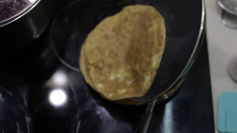 the process of cooking homemade pancakes. woman puts pancake from pan to plate