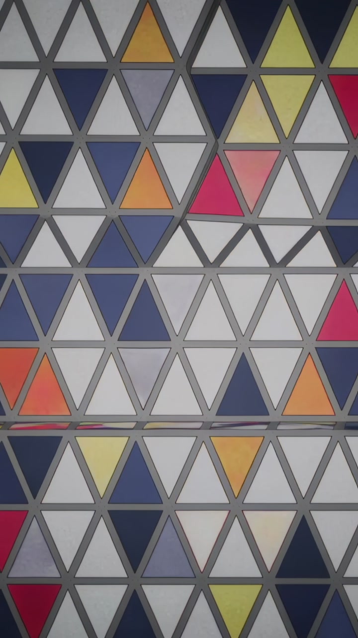 Vertical video: Panning camera showing triangular tile panel at lobby with colored inserts and seam