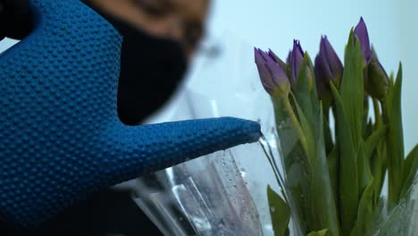 volunteer florist waters a fresh bouquet of tulips