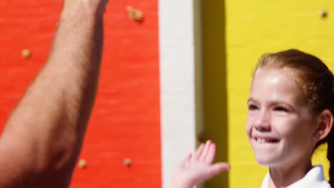 school kids giving high five to coach