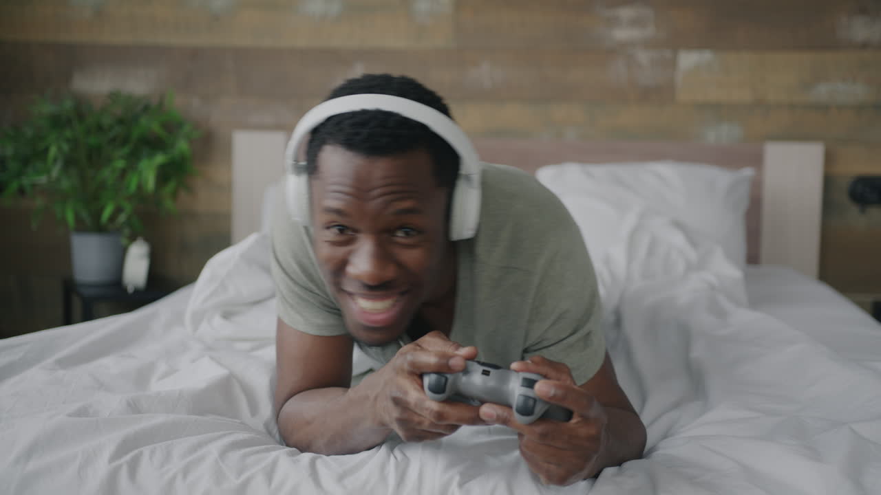 uomo che gioca a videogiochi a letto