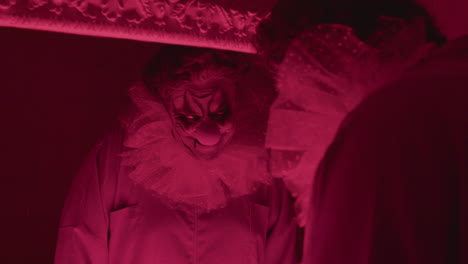 un clown dans une salle de bain avec une lumière rouge