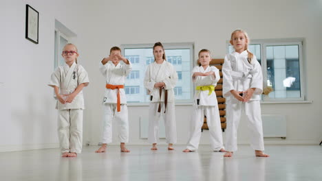 Kids-in-white-kimono-and-teacher-in-martial-arts-class