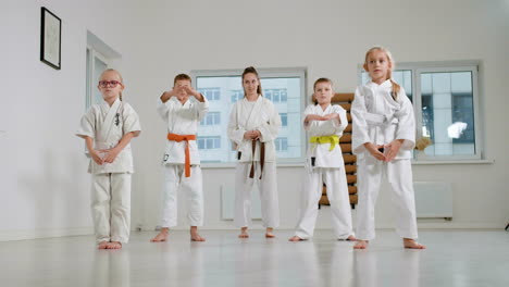 kids in white kimono and teacher in martial arts class