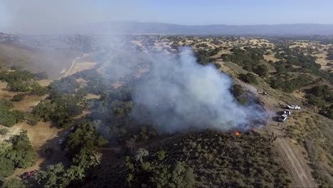 los bomberos encienden una quema de control en la parte superior de una cresta