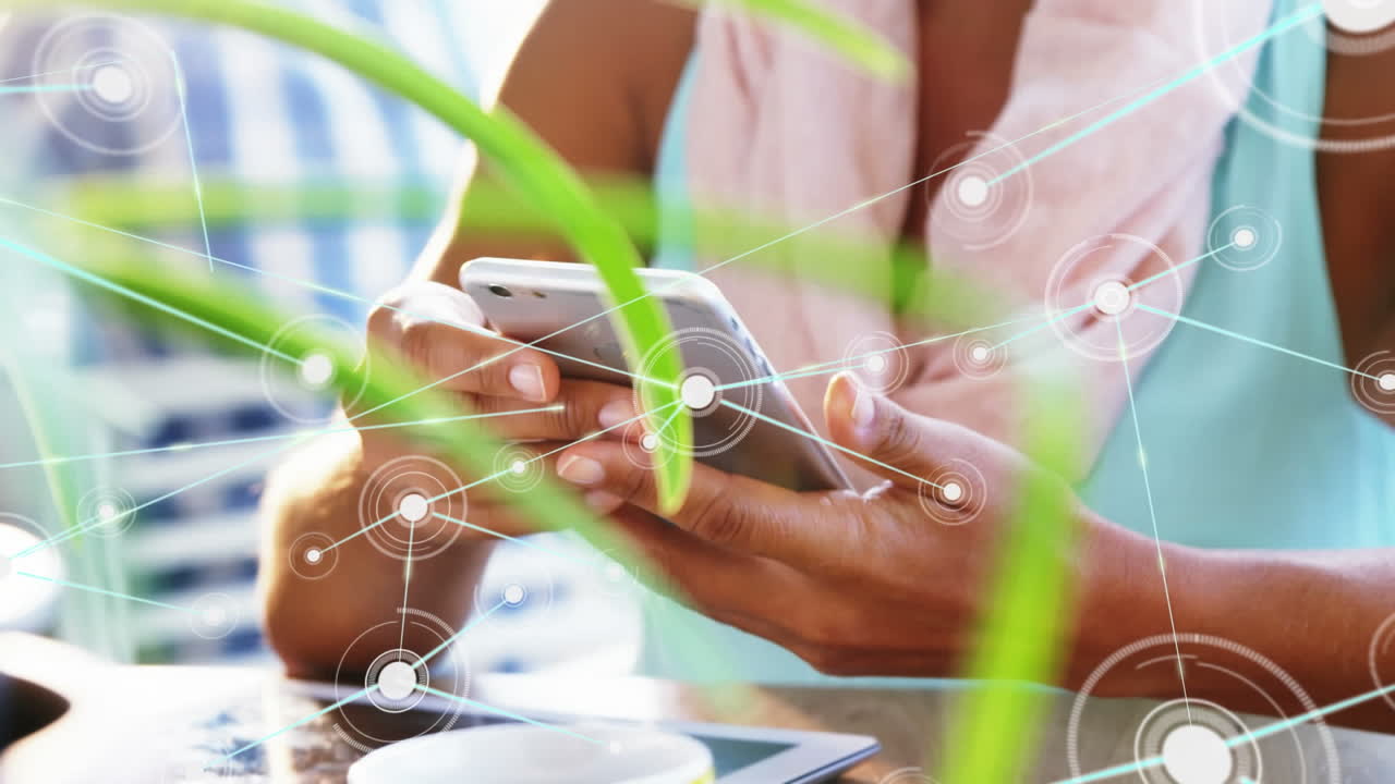Animation of network of connections over mid section of woman using smartphone at a cafe