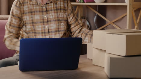 el propietario de una pequeña empresa prepara productos para entregarlos a los clientes mientras trabaja en casa en cuarentena