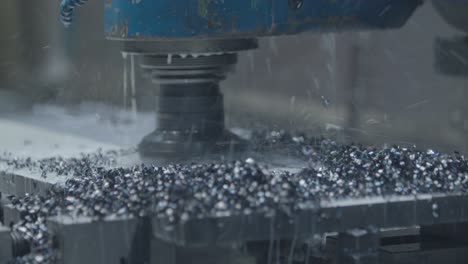máquina de fresado de metales en funcionamiento, tallando a través del acero con fragmentos de metal dispersos en todas las direcciones