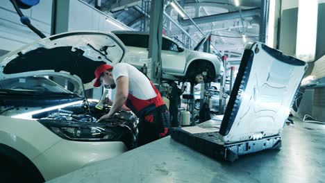 automobile service, car mechanic. auto mechanic uses a laptop while conducting diagnostics test