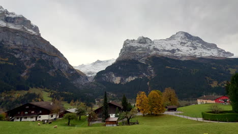 Grindelwald-Switzerland-Swiss-Alps-valley-village-resort-ski-town-snowy-Jungfrau-Junfrangu-Lauterbrunnen-mountain-glacier-glacial-peaks-October-cloudy-autumn-evening-landscape-pan-to-the-left