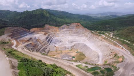 aerial view overlooking a large open pit at a gold mine, sunny day