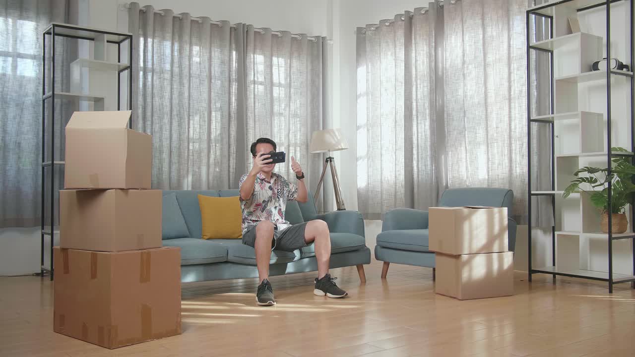 이동 상자들로 둘러싸인 새로운 집에서 vr 헤드으로 셀피를 찍는 남자.