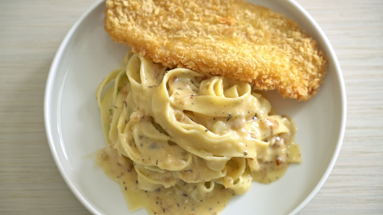 생선 튀김을 곁들인 홈메이드 페투치니 파스타 화이트 크림 소스