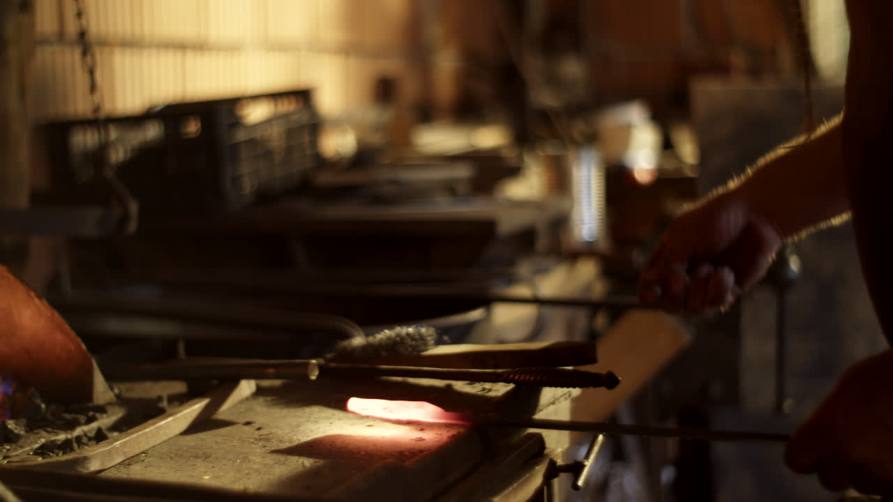 herrero que trabaja con metal caliente