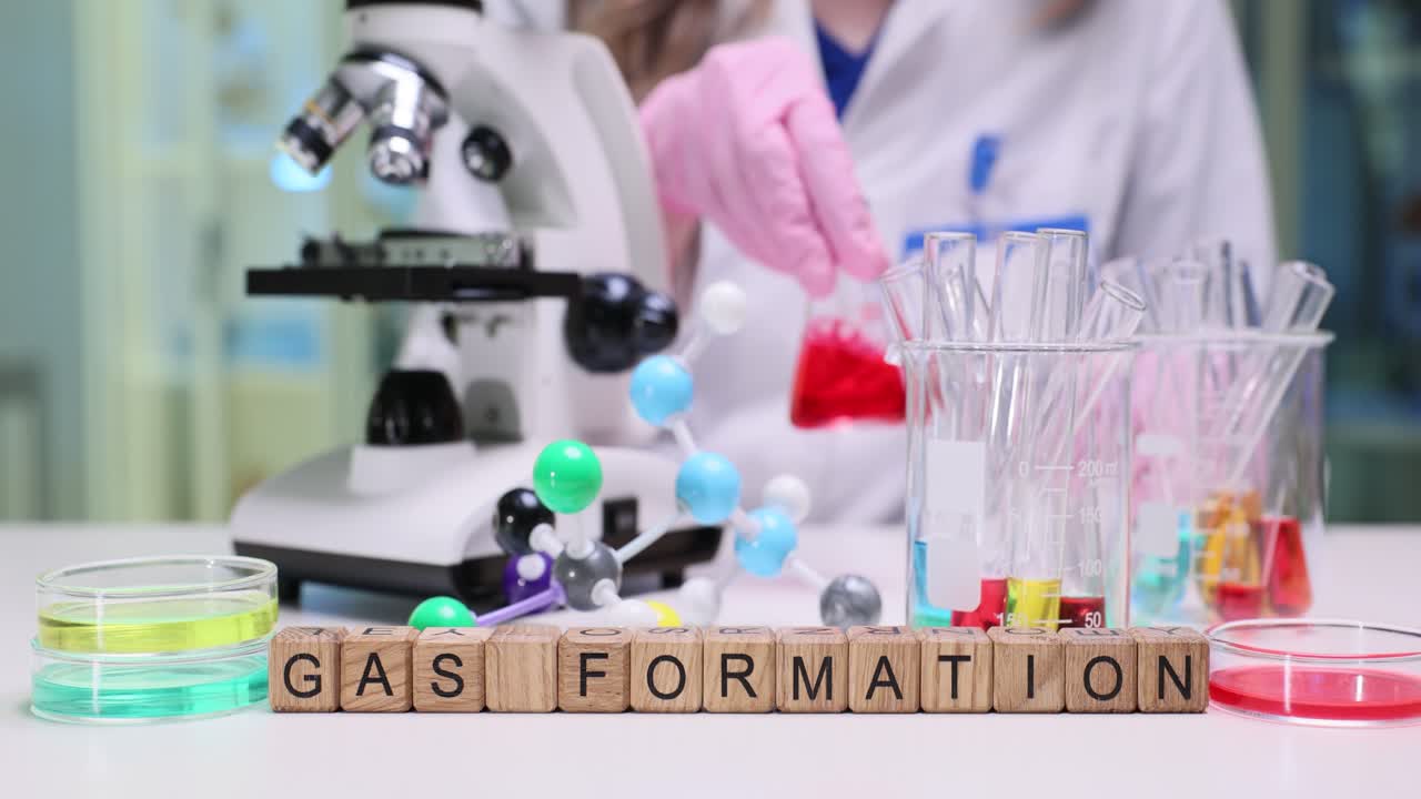 Cubetti di legno compongono la frase formazione di gas su scrivania da laboratorio vicino a vetreria