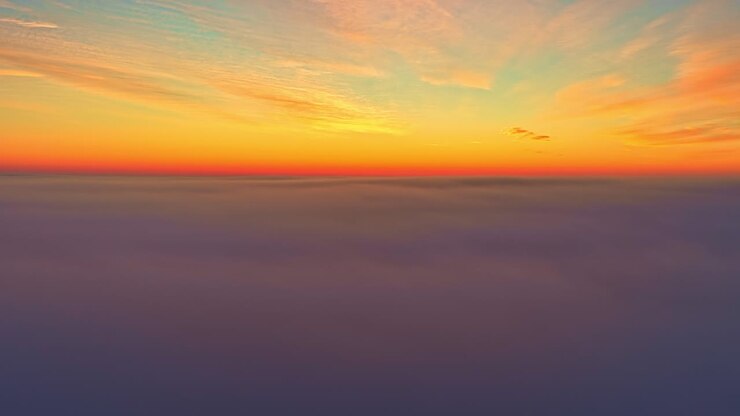 Vibrant sunset sky above clouds creating a serene and dreamy atmosphere