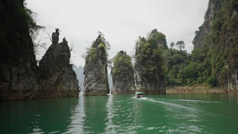 boat navigating among towering limestone karsts on a tranquil lake