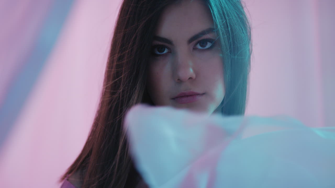 fantasía multicolor mujer joven hermosa buscando seductora entre las sábanas sensual belleza femenina cortinas soplando en un fondo colorido