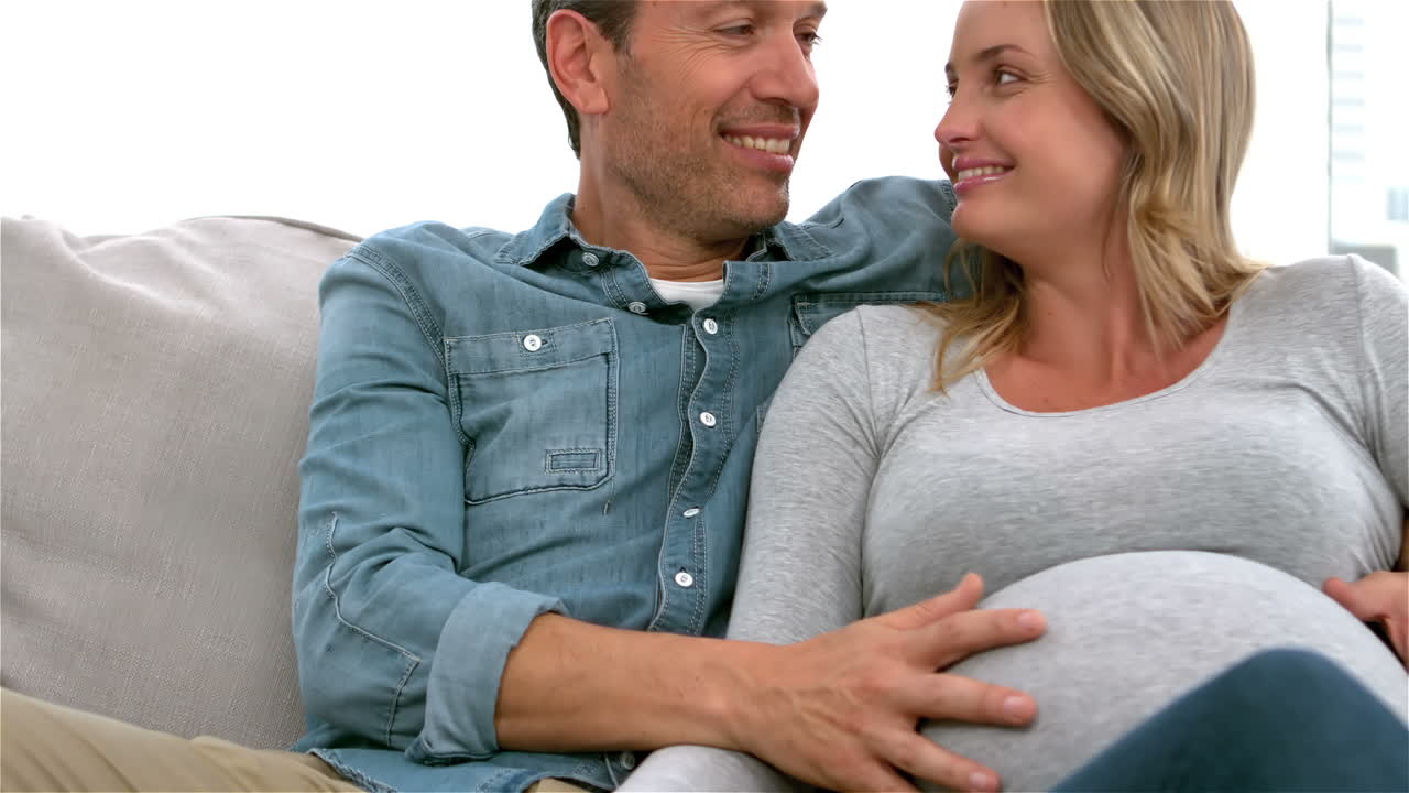 Happy future parents on sofa