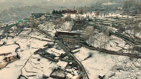 Drone-Orbital-Descendente-Filmado-Cinematográficamente-Durante-La-Nieve-En-La-Montaña-De-Karimabad-En-El-Norte-De-Pakistán-Hunza