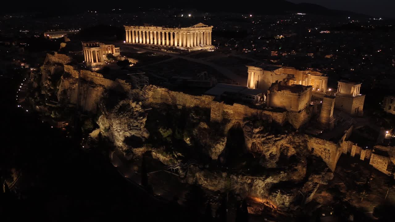Athens, Aerial view of Beautifully illuminated Acropolis at night, circle pan left slowly from a distance,Full view of Panthenon,Erechthenion and entrance of Acropolis in shimmering lights