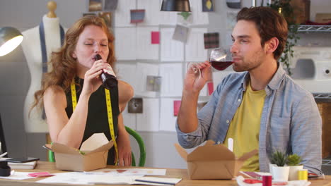 male and female owners of fashion business celebrating with drink at the end of working day