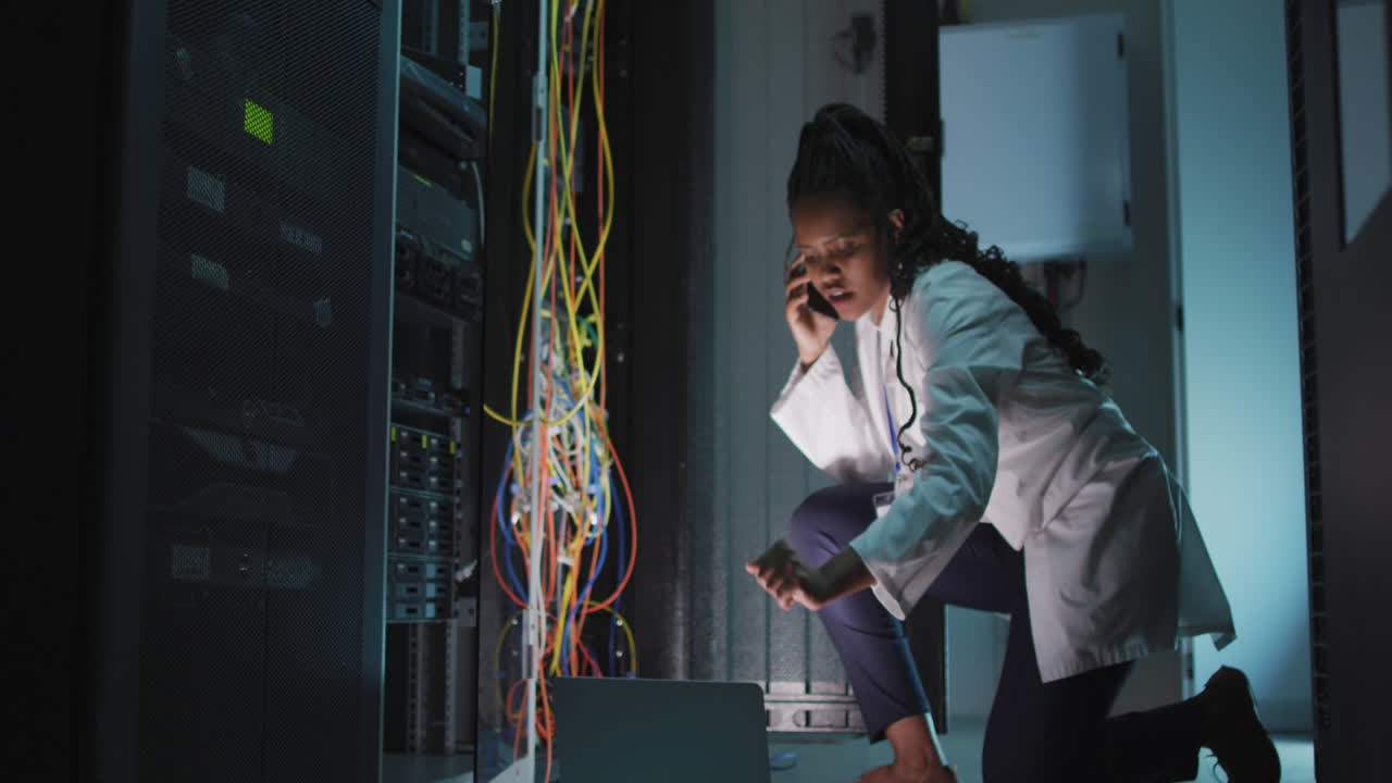 Animation of data processing over african american female engineer using laptop at server room