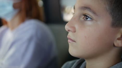 Close-up-of-a-boy's-face-while-he-watches-and-play-arcade-game-and-talks-to-his-mother