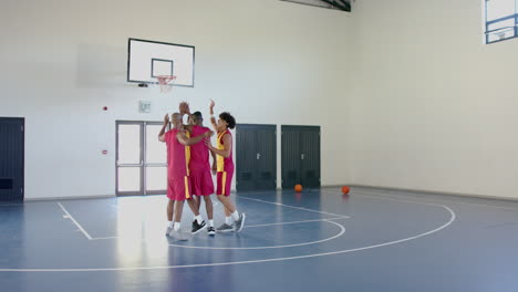 hombres afroamericanos celebran una puntuación en un juego de baloncesto en un gimnasio