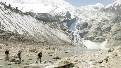 la pareja pasa por el arroyo del lago de montaña birendra en nepal, en la zona de manaslu.