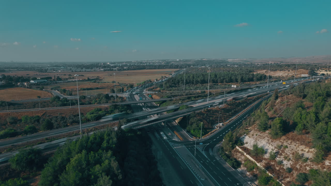 гиперлапс дрона по кругу вокруг главного перекрестка, расположенного в лесу, с голубым небом на заднем плане